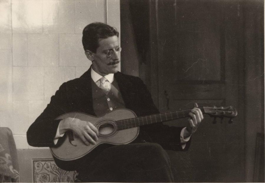 James Joyce assis, jouant de la guitare, Zurich, 1915